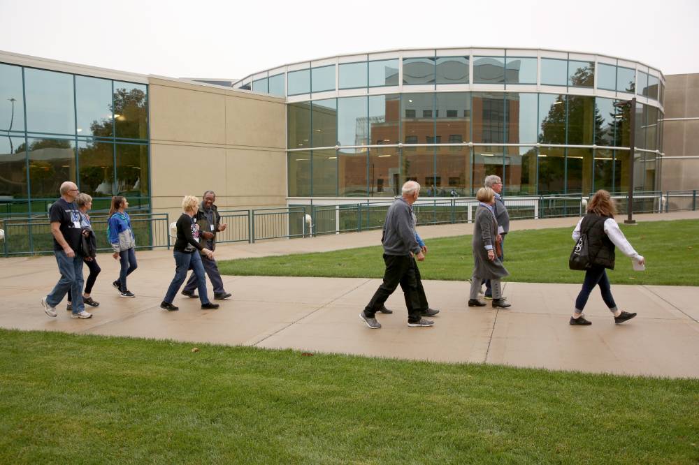 Class of '68 walks outside the Recreation Center on the campus tour.